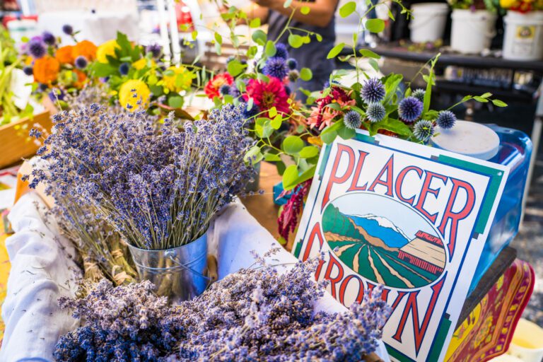 Placer Grown sign amidst fresh flowers at a market